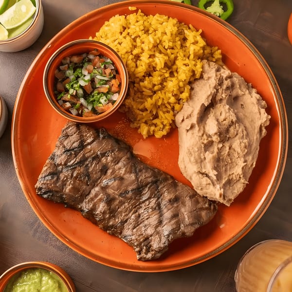 Grilled steak, yellow rice, refried beans, and pico de gallo on an orange plate.