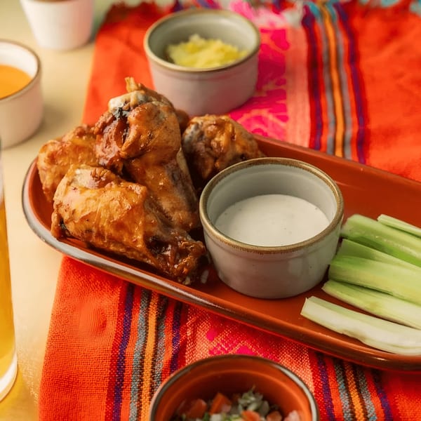 Polanco Taqueria's chicken wings with ranch and celery on a vibrant Mexican-themed tablecloth.